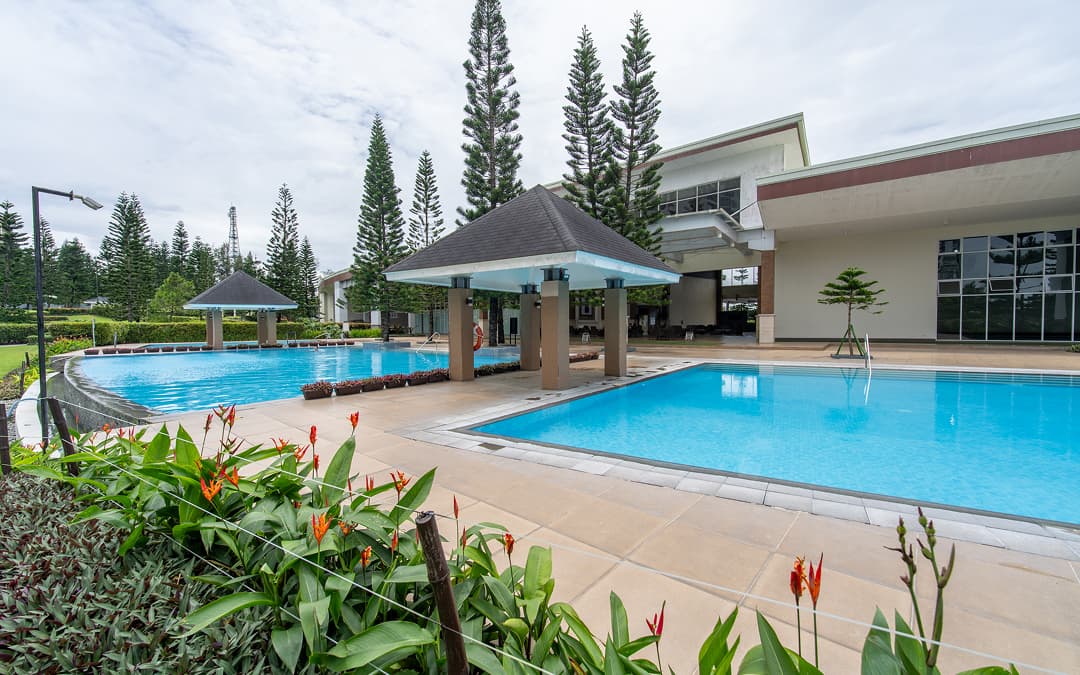 Outdoor swimming pool surrounded by tropical greenery