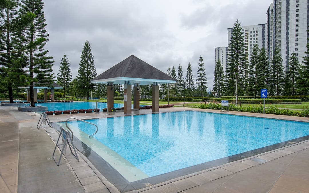 An outdoor swimming pool surrounded by tropical palm trees